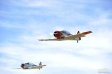Two T-6 class fighters in the air during the National Championship Air Races, which features some of the most exciting racing at Reno with an emphasis on strategy and pilot skill rather than raw horsepower